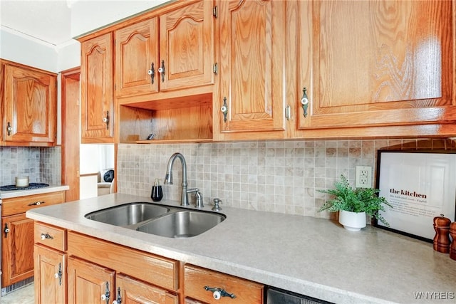 kitchen with a sink, backsplash, light countertops, brown cabinetry, and open shelves