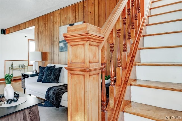 living room featuring stairway and wood walls