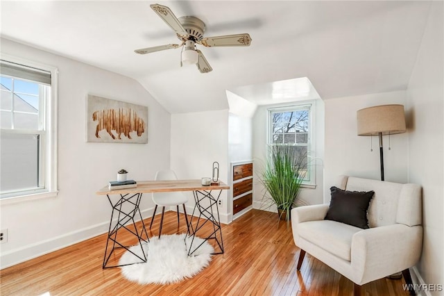 living area with baseboards, light wood finished floors, ceiling fan, and vaulted ceiling