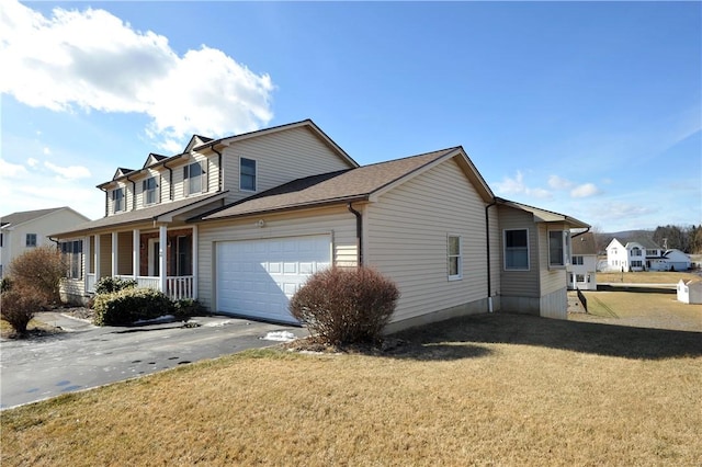 view of home's exterior with a garage, aphalt driveway, a yard, and covered porch