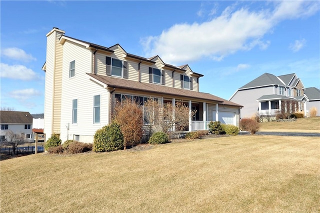 view of front of home with a garage, a chimney, and a front yard