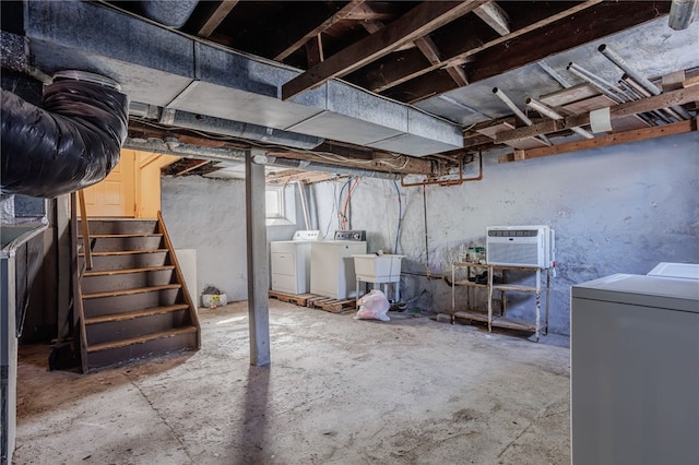 unfinished basement with a sink, a wall mounted air conditioner, stairs, and separate washer and dryer