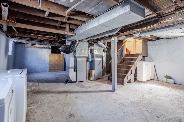 unfinished basement with heating unit, washer and clothes dryer, and stairs