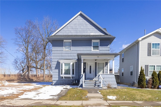 american foursquare style home with covered porch and roof with shingles