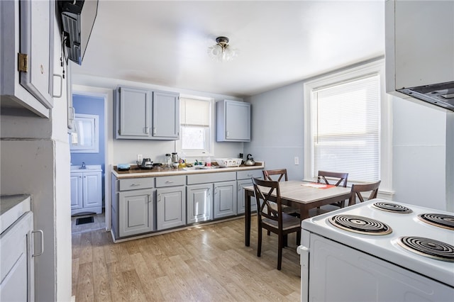 kitchen featuring light countertops, electric range, light wood-style flooring, and gray cabinets