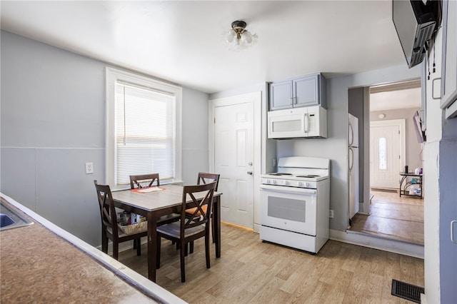 kitchen with visible vents, white appliances, plenty of natural light, and light wood-style flooring