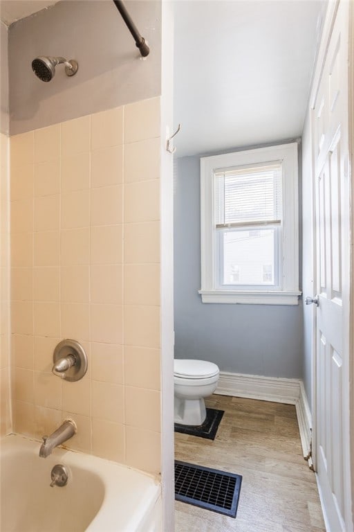 full bath featuring visible vents, baseboards, toilet, bathing tub / shower combination, and wood finished floors