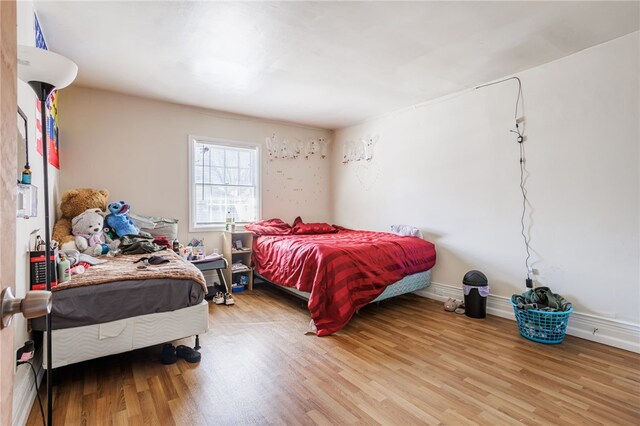 bedroom featuring baseboards and wood finished floors