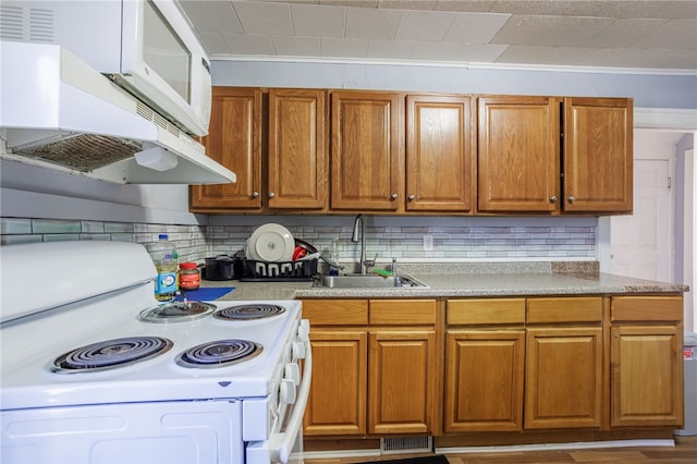 kitchen with tasteful backsplash, white appliances, extractor fan, and a sink