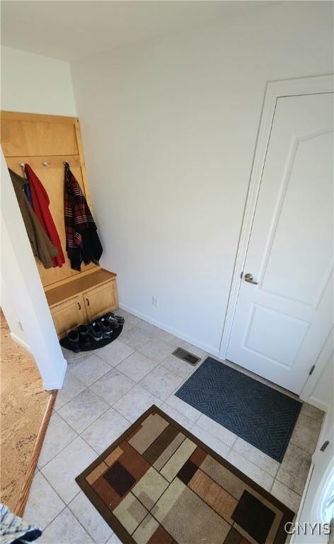 mudroom featuring light tile patterned floors, baseboards, and visible vents