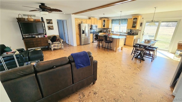 living area featuring visible vents and ceiling fan