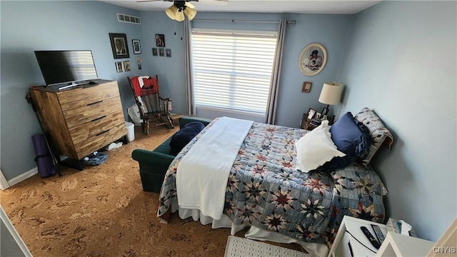 carpeted bedroom featuring visible vents, baseboards, and a ceiling fan