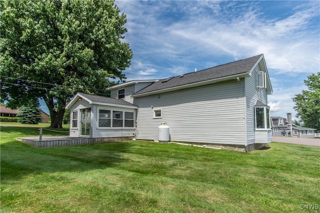 back of house with a lawn and a sunroom