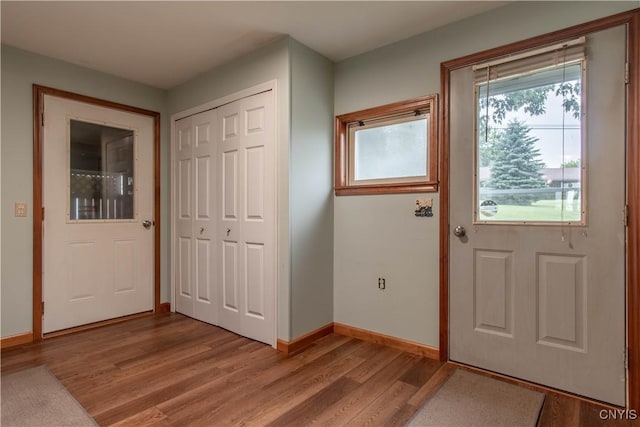 foyer entrance featuring baseboards and light wood finished floors