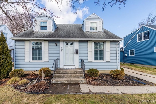 new england style home with roof with shingles