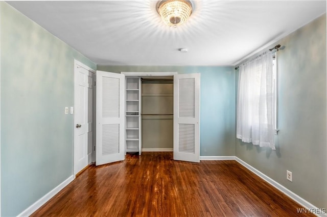 unfurnished bedroom with a closet, baseboards, and wood finished floors