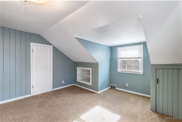 bonus room with visible vents, carpet floors, lofted ceiling, and built in shelves