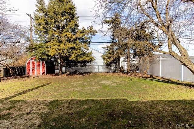 view of yard featuring an outdoor structure, a storage unit, and a fenced backyard