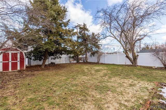 view of yard featuring an outbuilding, a storage shed, and a fenced backyard