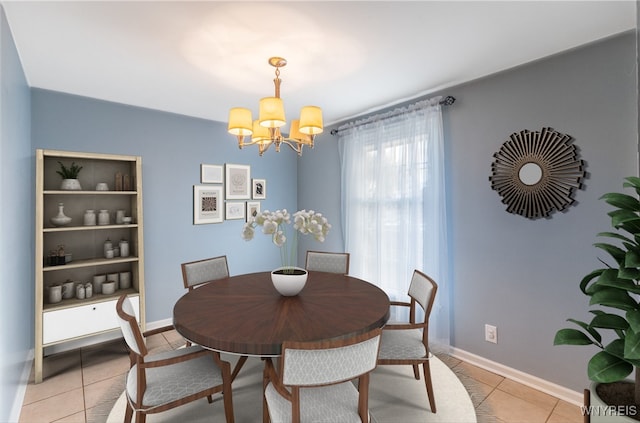 dining area featuring a notable chandelier, light tile patterned floors, and baseboards