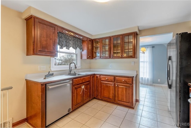 kitchen featuring plenty of natural light, brown cabinetry, appliances with stainless steel finishes, and a sink