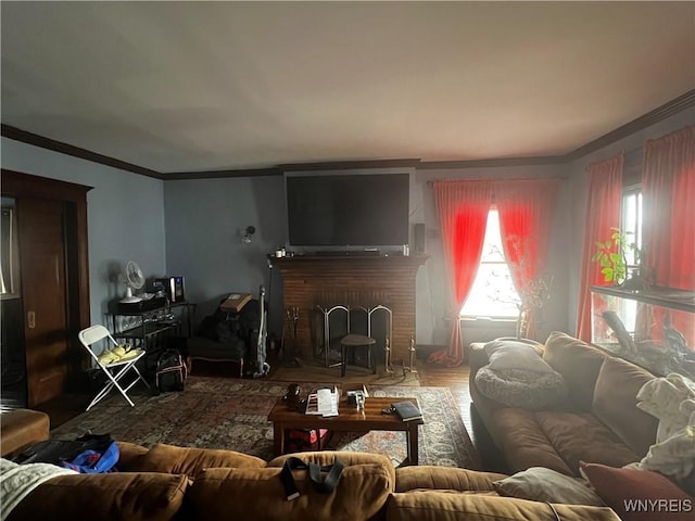 living room with wood finished floors, a brick fireplace, and ornamental molding