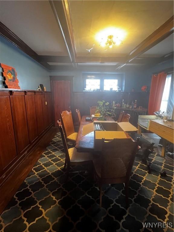 dining space with beamed ceiling, coffered ceiling, and dark wood-style flooring