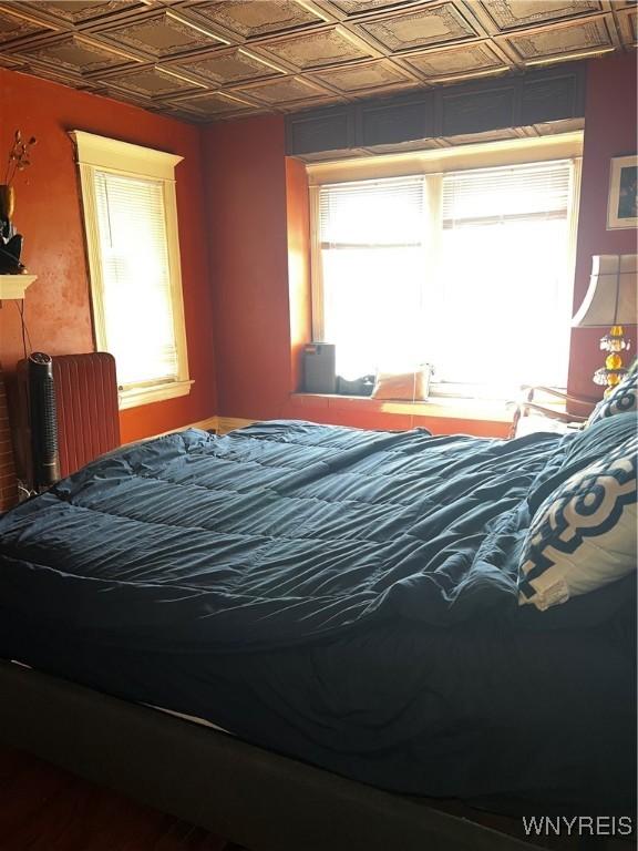 bedroom featuring multiple windows and an ornate ceiling