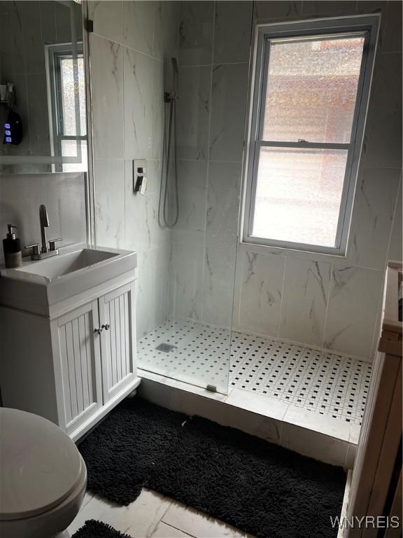 bathroom with a marble finish shower, toilet, vanity, and marble finish floor