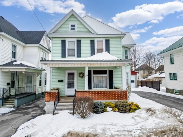 traditional style home with metal roof and covered porch