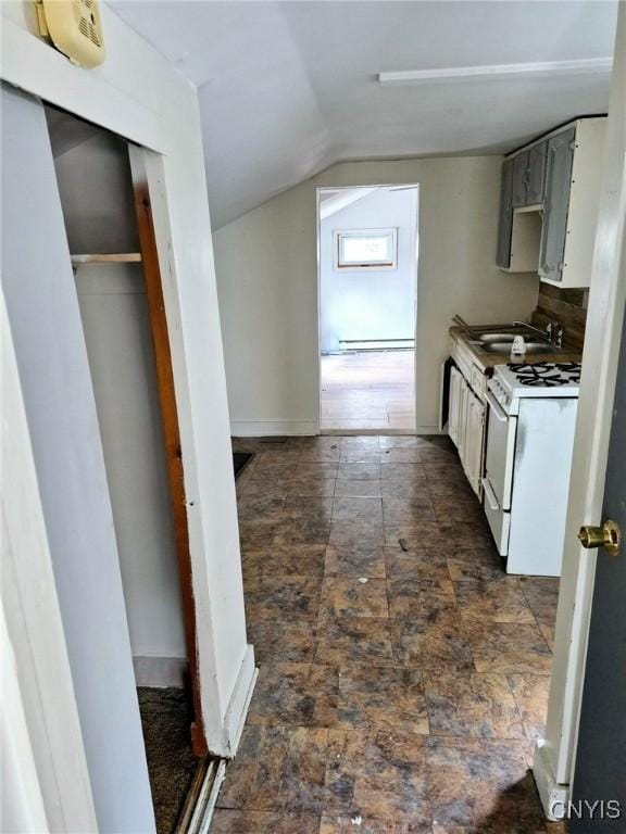 kitchen with a sink, vaulted ceiling, light countertops, white gas range oven, and baseboard heating