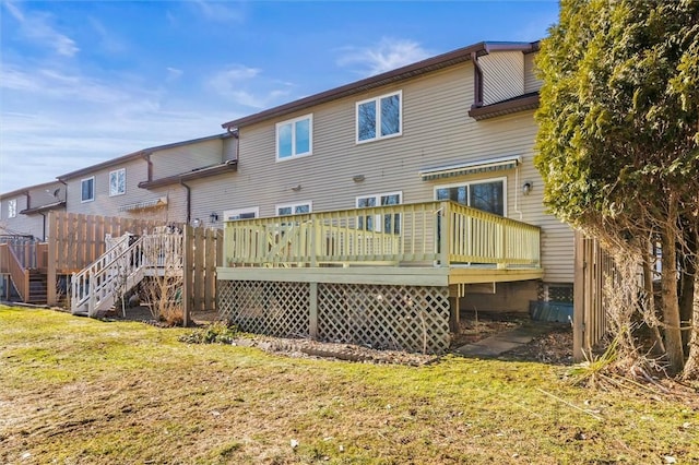 rear view of house featuring a wooden deck, a lawn, and stairway