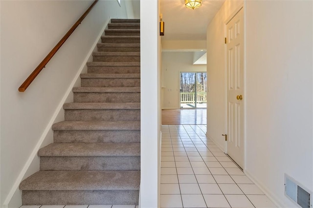 stairway with tile patterned floors and visible vents