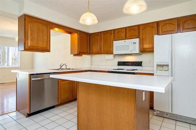 kitchen with white appliances, light countertops, and a sink