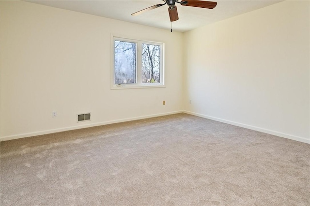 spare room featuring baseboards, visible vents, carpet floors, and ceiling fan