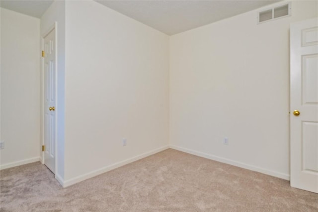 unfurnished room with light carpet, visible vents, and baseboards