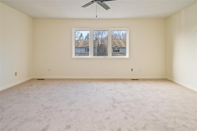 carpeted empty room featuring ceiling fan and baseboards