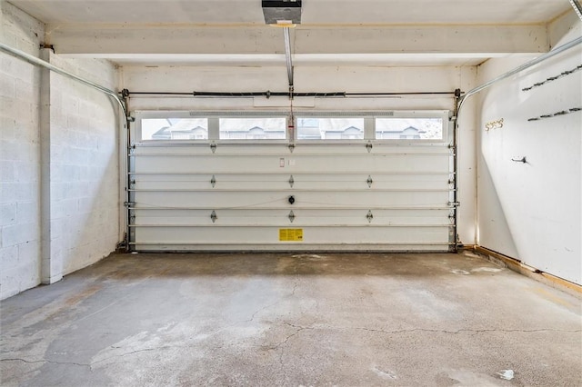 parking garage featuring concrete block wall and a garage door opener