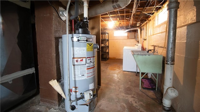 utility room featuring gas water heater, a sink, and washer and dryer