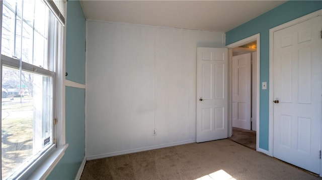 spare room featuring baseboards and carpet floors