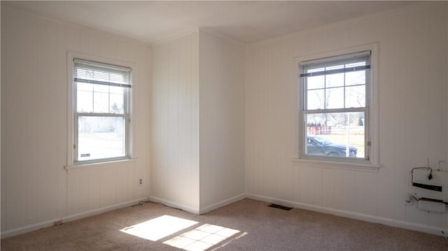 unfurnished room with visible vents, baseboards, carpet, and a healthy amount of sunlight