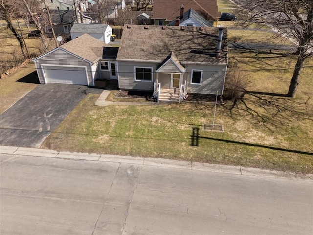 view of front of house with aphalt driveway, a garage, and a front lawn