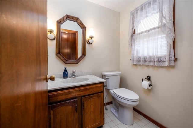 bathroom with baseboards, toilet, and vanity