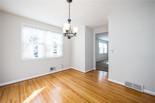 unfurnished dining area with visible vents, baseboards, and wood finished floors