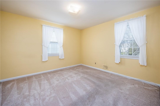 carpeted empty room featuring baseboards