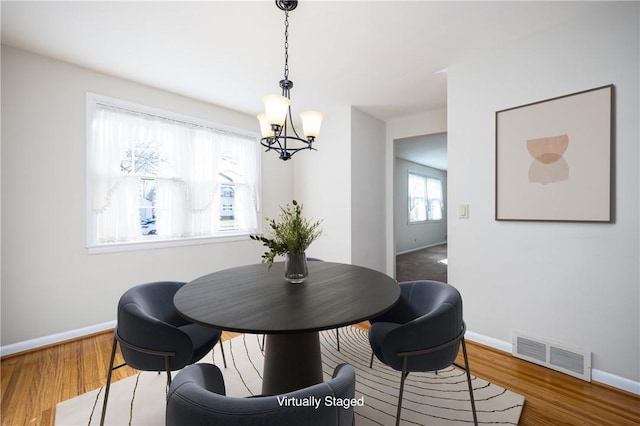 dining room with visible vents, baseboards, an inviting chandelier, and wood finished floors