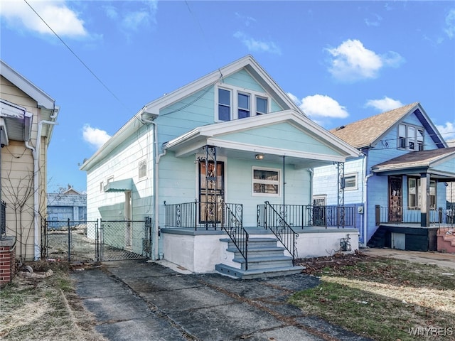 view of front of property featuring fence, a porch, and a gate