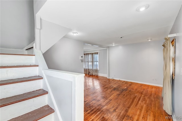 stairway featuring wood finished floors and baseboards