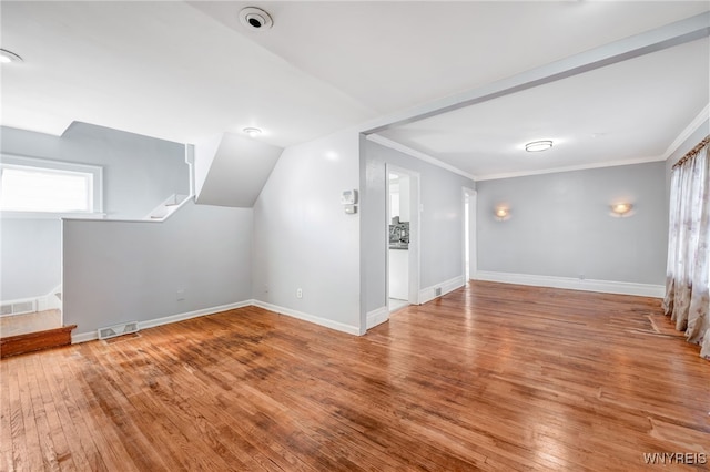 additional living space featuring visible vents, wood-type flooring, baseboards, and stairway