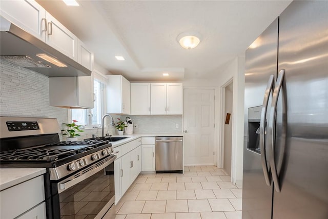 kitchen featuring backsplash, under cabinet range hood, light countertops, stainless steel appliances, and a sink